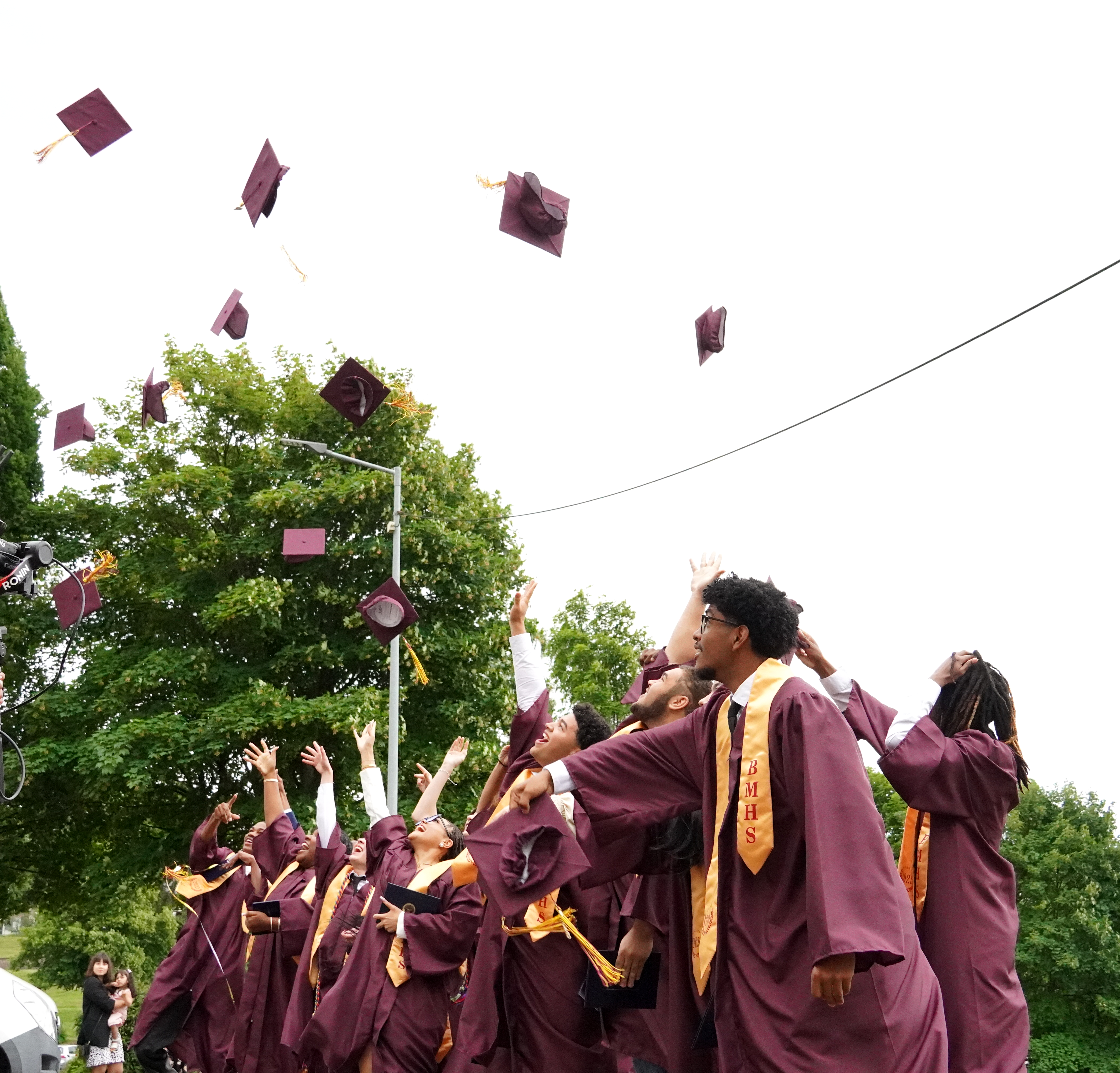 The Class of 2025 celebrates by throwing their caps in the air. 